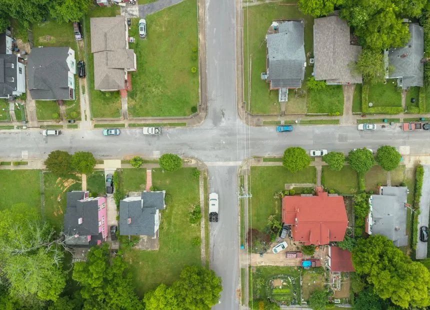 Aerial view of established tree-lined suburban streets with pitched shingle roofs